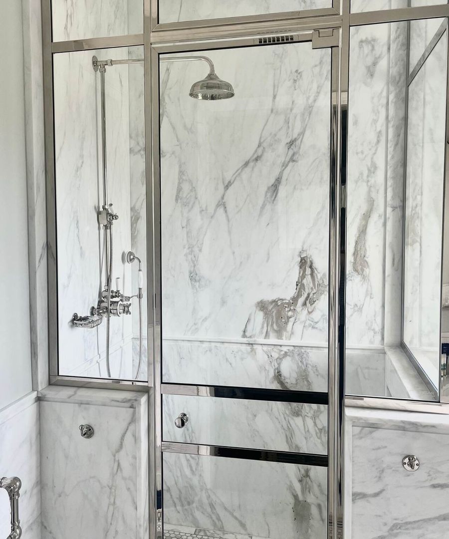 Frameless shower enclosure in a marble bathroom