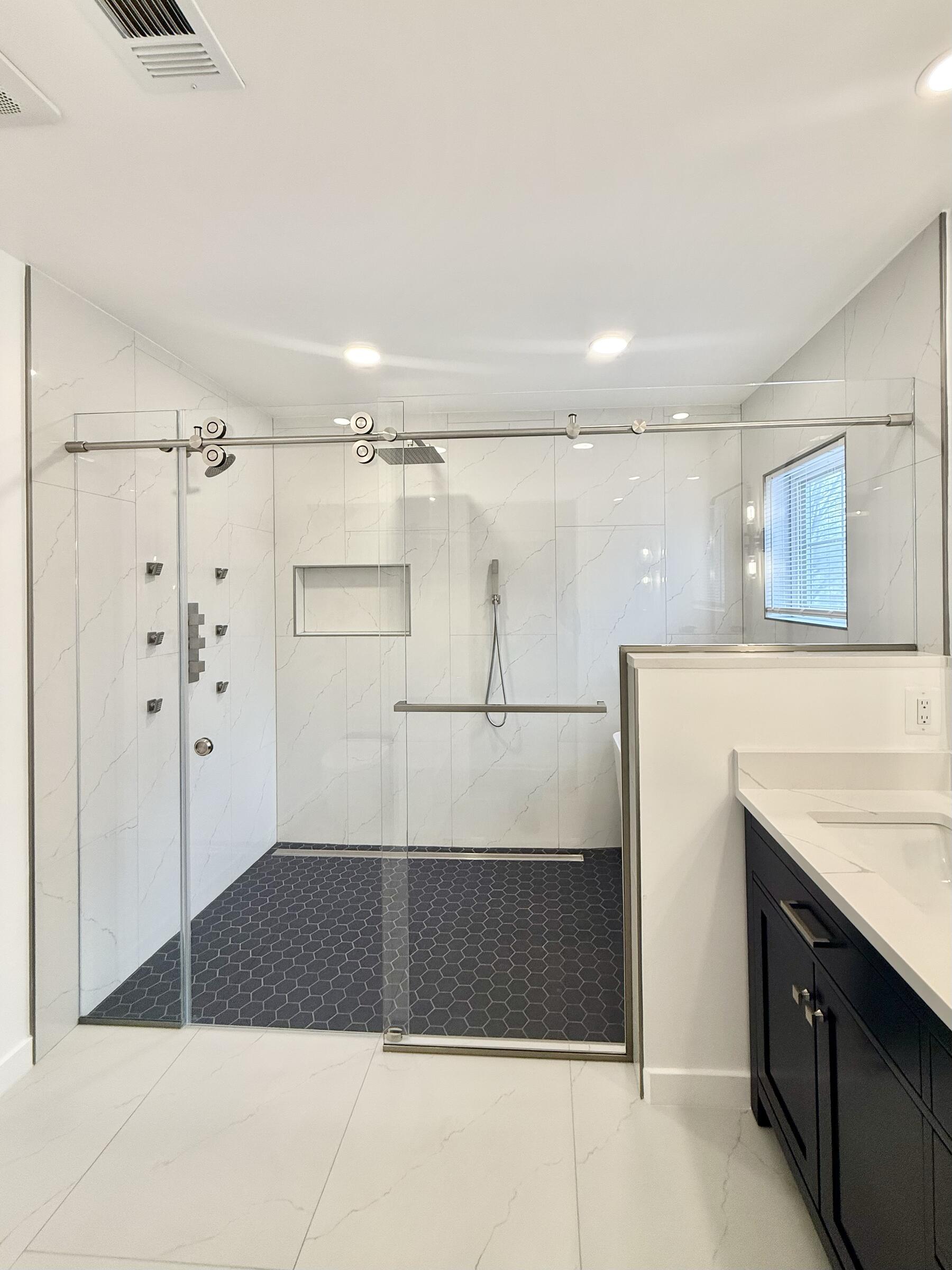 Frameless glass shower enclosure