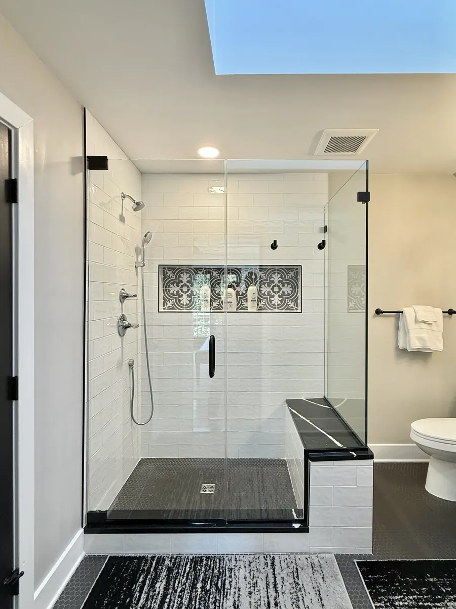 90 degree corner frameless glass shower enclosure, matte black hardware, black stone