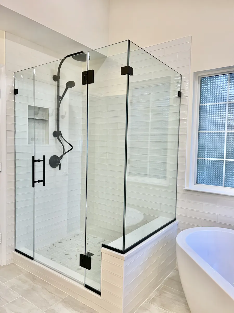 90 degree corner frameless glass shower enclosure, matte black hardware, ladder pull and notched panel whit tile