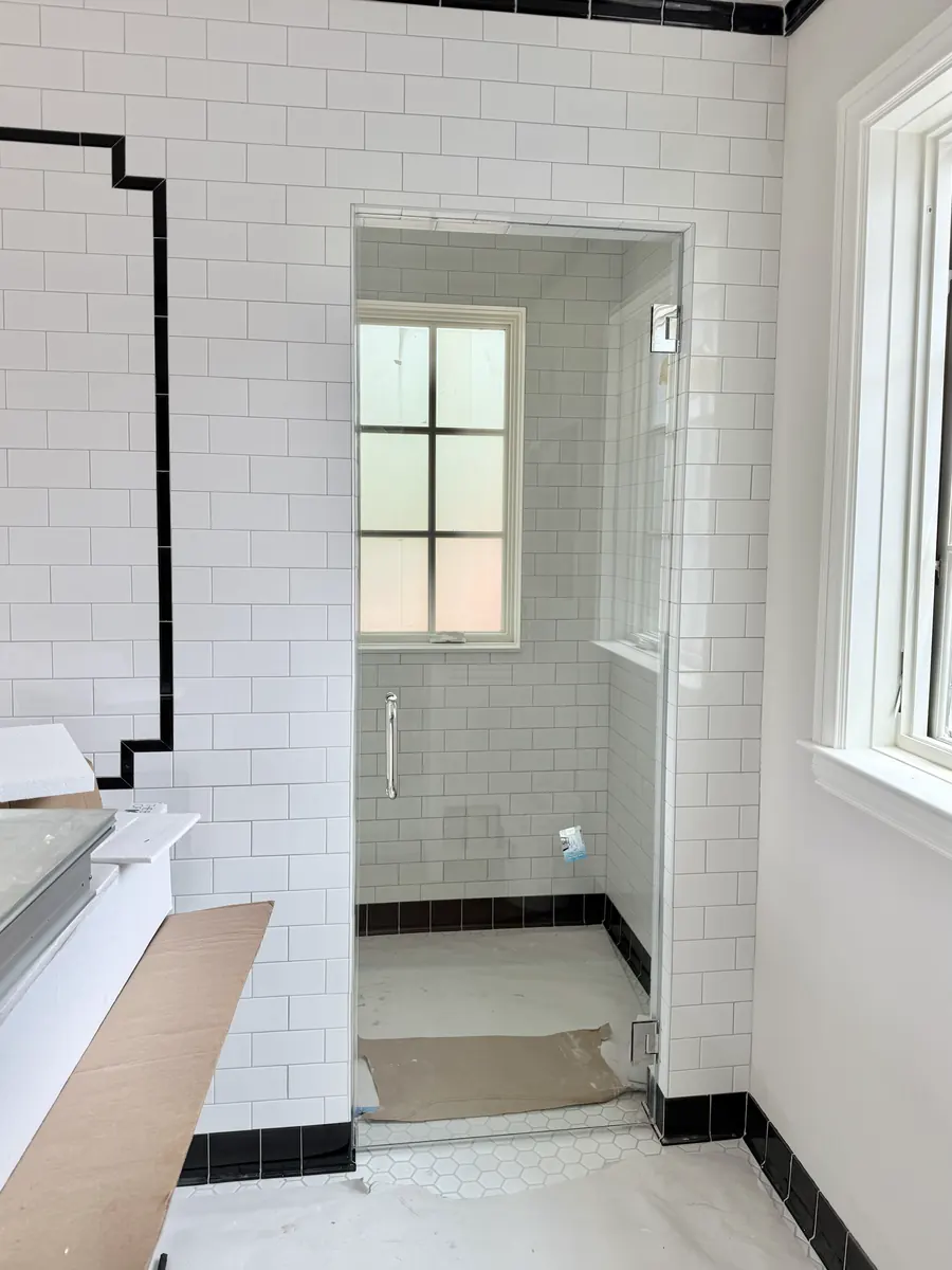 Frameless glass shower enclosure, polished chrome hardware
