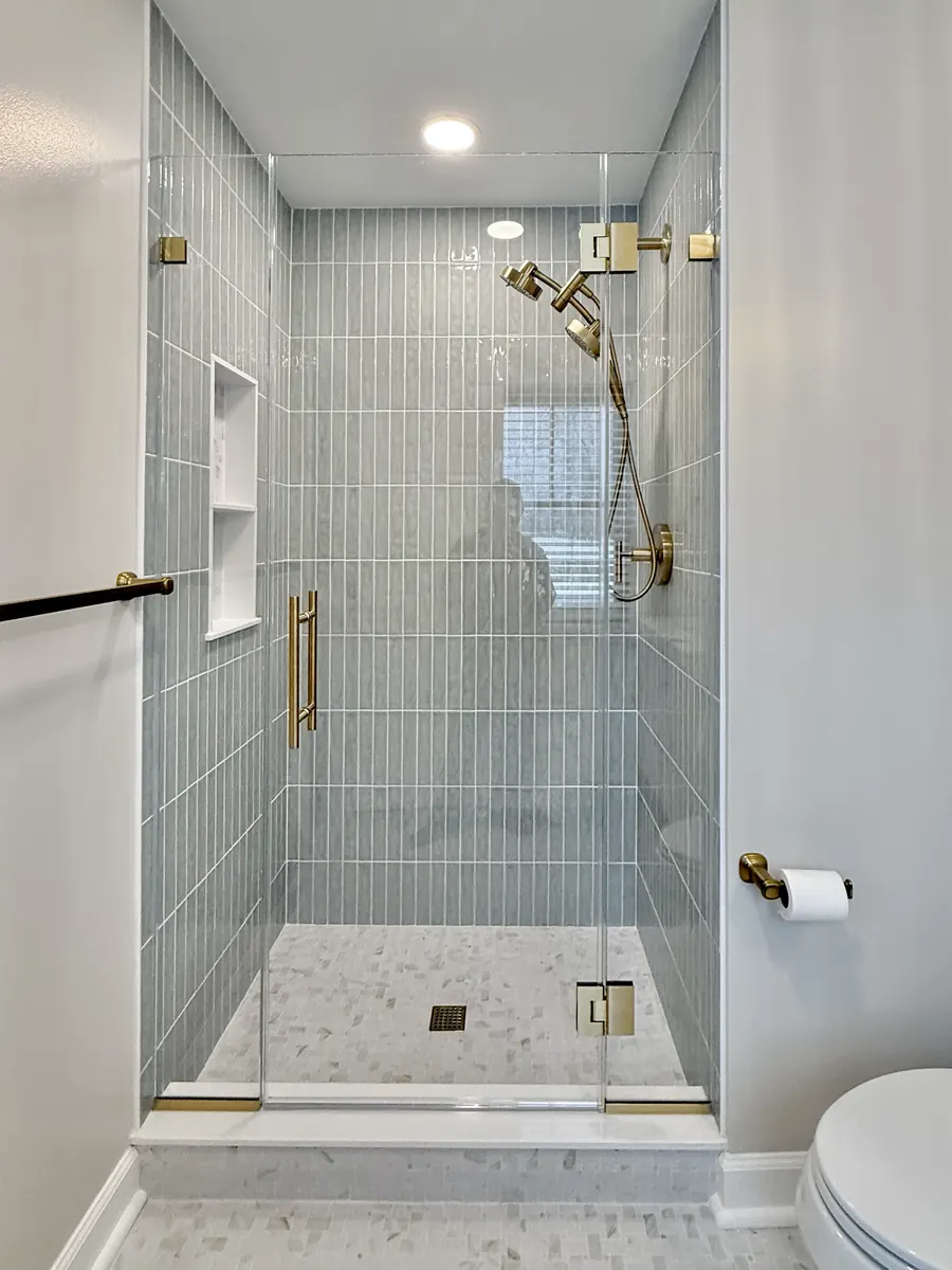 In-line panel frameless glass shower enclosure, satin brass hardware, ladder pull