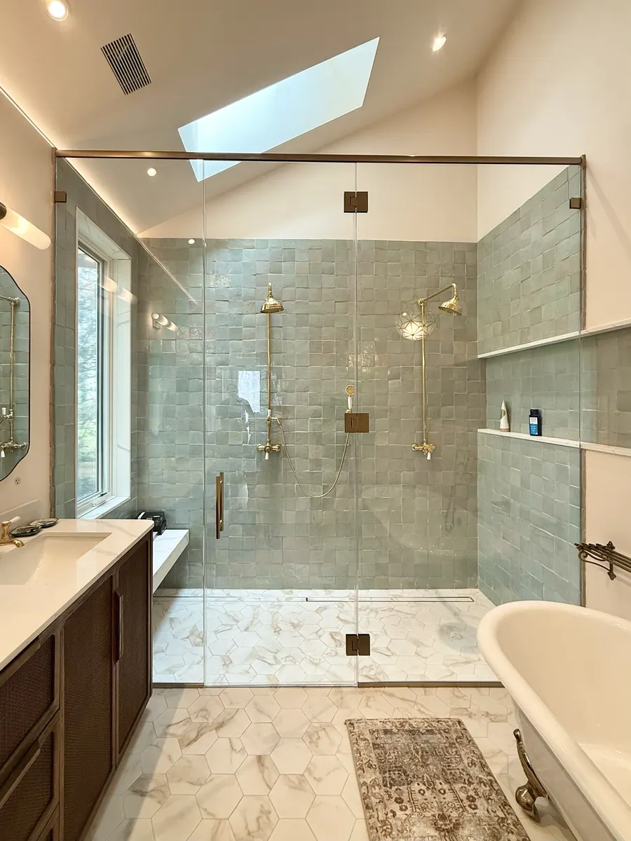 In-line panel frameless glass shower enclosure, brushed bronze hardware