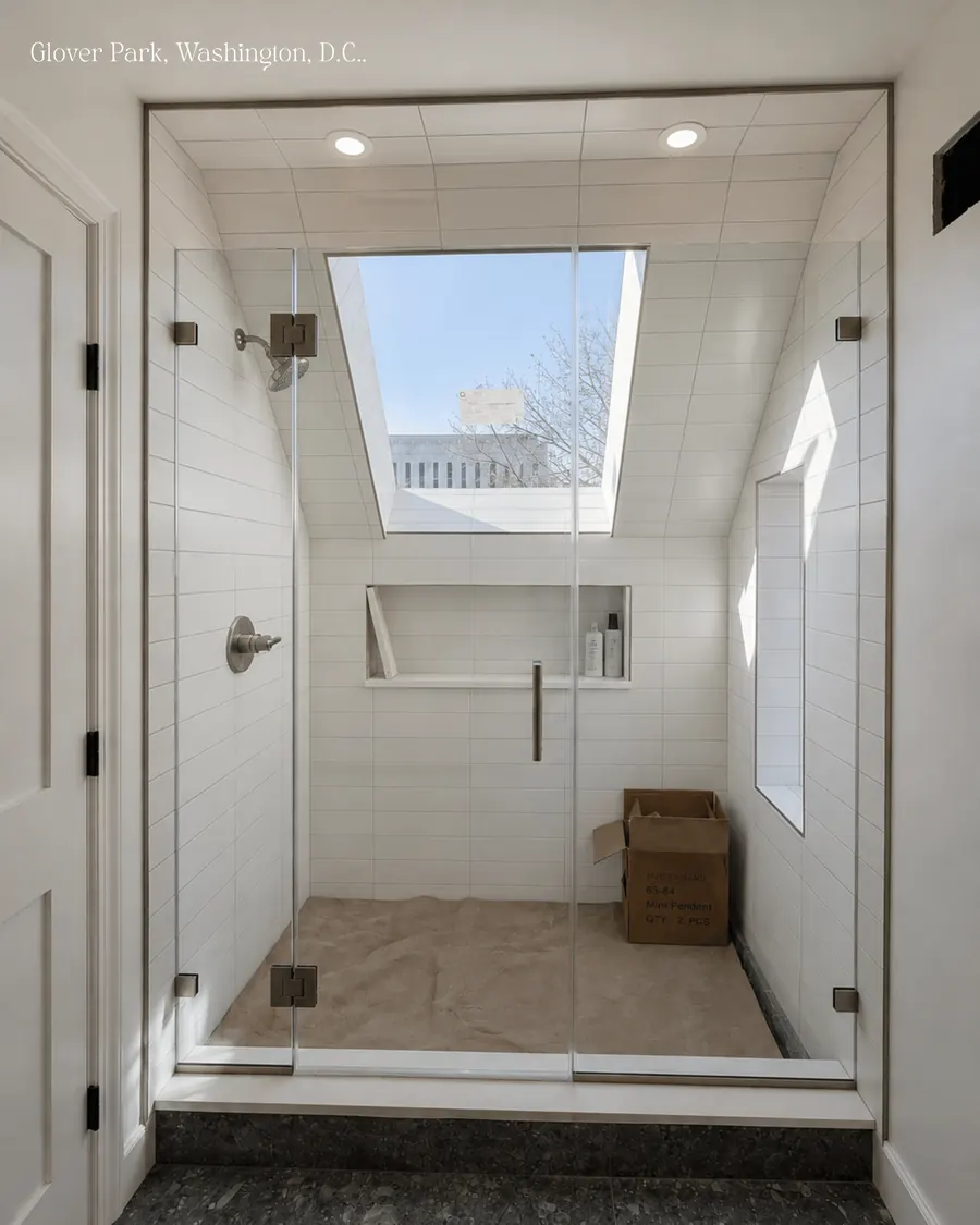 In-line panel frameless glass shower enclosure, brushed nickel hardware, skylight