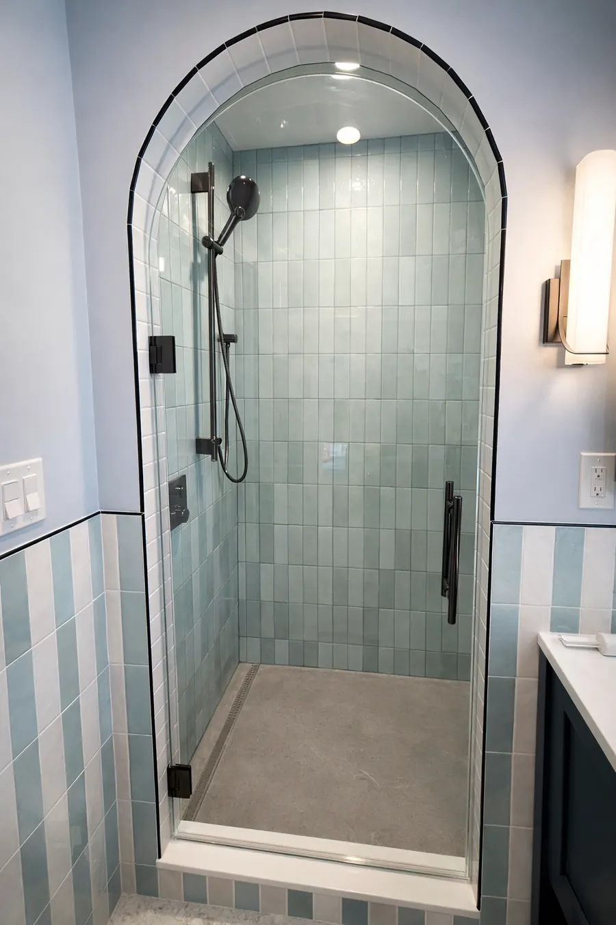 Frameless glass shower enclosure, matte black hardware, blue tile, Arched Glass Shower Door