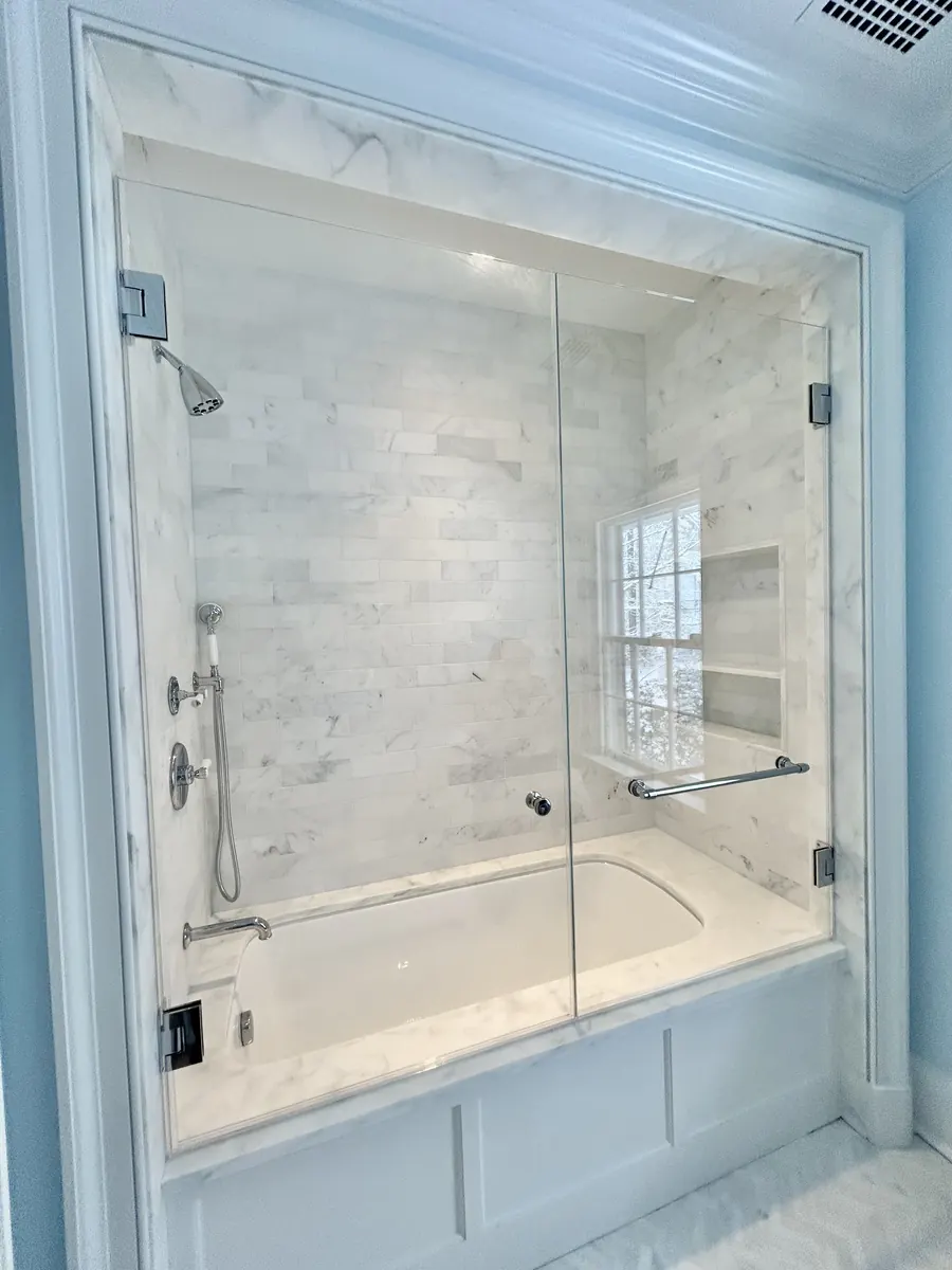 Door and panel frameless glass shower enclosure, over a tub, polished chrome hardware, Tub Shower Door in McLean