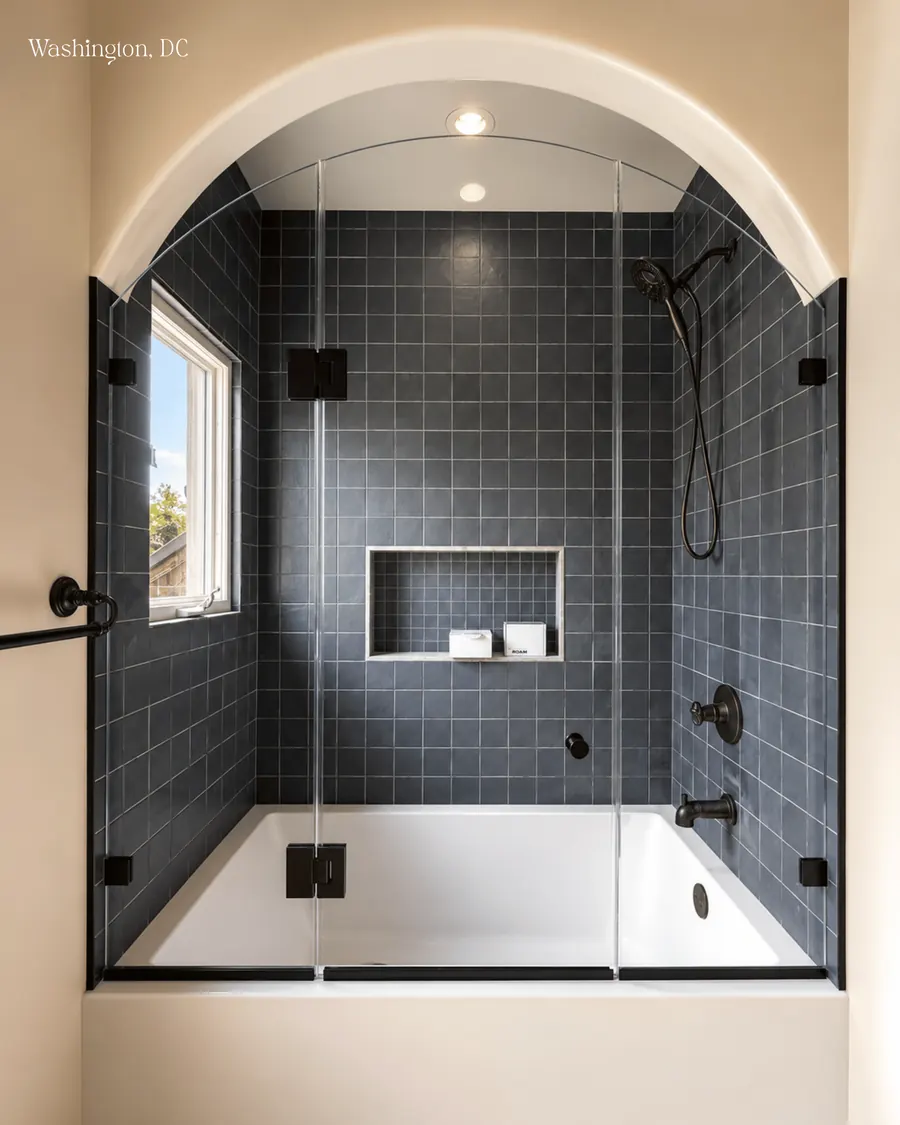 Frameless glass shower enclosure, over a tub, matte black hardware, arched glass
