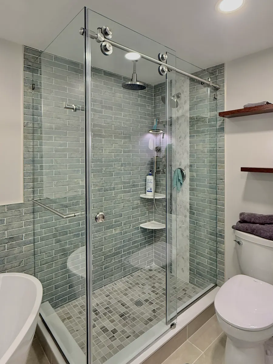 Titan series frameless sliding shower door, with a 90 degree return panel, brushed nickel hardware