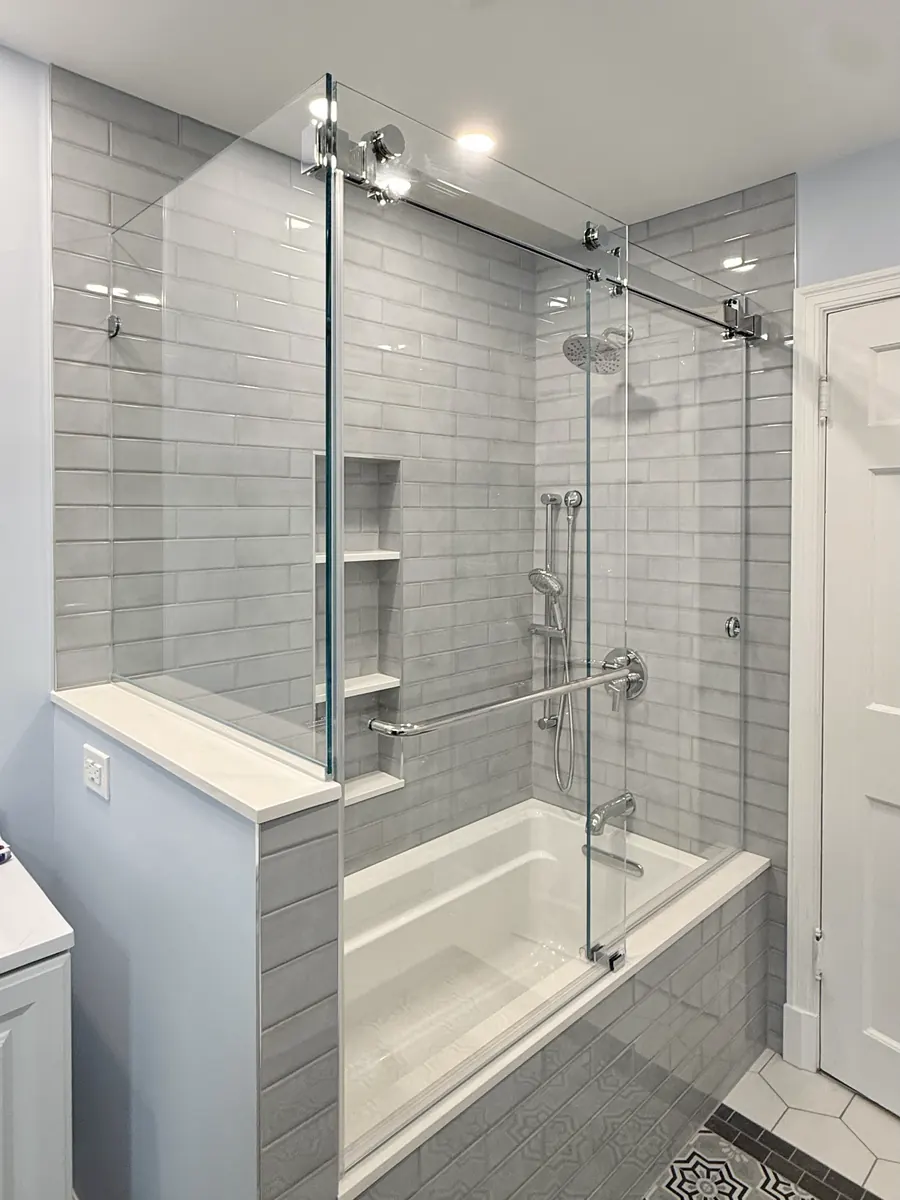 Titan Duo series frameless sliding shower door, over a tub, polished chrome hardware