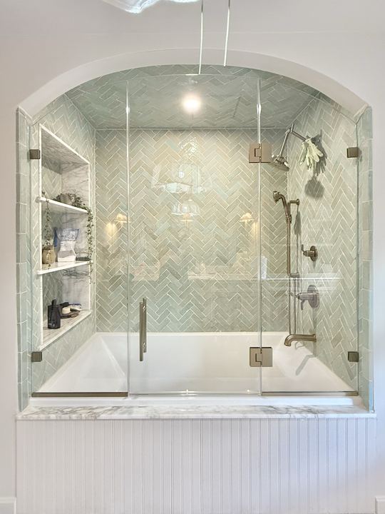 Frameless tub enclosure with herringbone tile